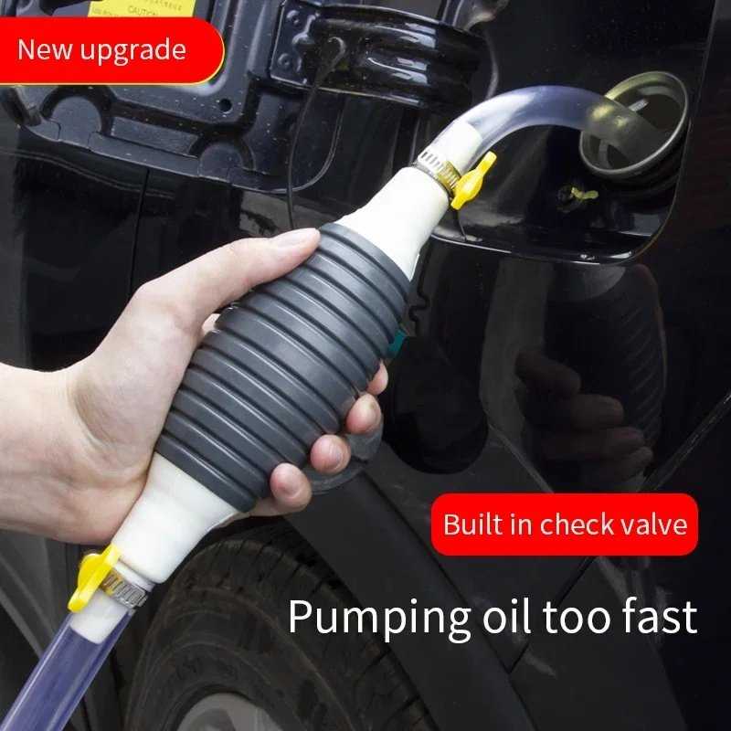 Pompa tangan menyedot bensin dari tangki mobil dengan satu tangan